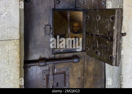 Schwere mittelalterliche Gefängniszellentür aus Holz mit offener Luke, die den Gefangenen im Schloss Château de Bouillon, Provinz Luxemburg, Ardennen, Belgien zeigt | Diorama montrant prisonnier en prison dans le Château de Bouillon, Luxemburg, Ardennen, Belgique 27/08/2018 Stockfoto