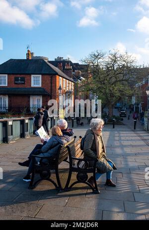 Menschen, die auf einer Bank auf einer Brücke sitzen, die Windsor und Eton in Berkshire , England , Vereinigtes Königreich verbindet Stockfoto