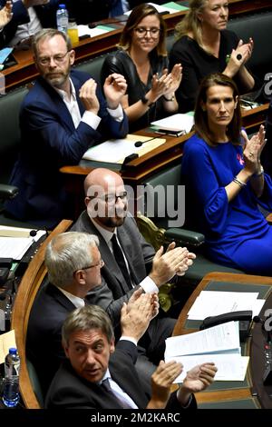 Der belgische Premierminister Charles Michel, der stellvertretende Ministerpräsident und Minister für Beschäftigung, Wirtschaft und Verbraucherschutz Kris Peeters sowie der stellvertretende Ministerpräsident und Innenminister Jan Jambon applaudieren nach der Abstimmung auf einer Plenarsitzung der Kammer des bundesparlaments in Brüssel. Mit der Abstimmung über die politische Erklärung des belgischen Premierministers vom Montag, dem 10. Oktober 2018. BELGA FOTO DIRK WAEM Stockfoto