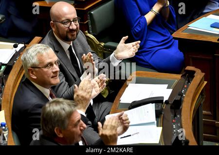 Der belgische Premierminister Charles Michel, der stellvertretende Ministerpräsident und Minister für Beschäftigung, Wirtschaft und Verbraucherschutz Kris Peeters sowie der stellvertretende Ministerpräsident und Innenminister Jan Jambon applaudieren nach der Abstimmung auf einer Plenarsitzung der Kammer des bundesparlaments in Brüssel. Mit der Abstimmung über die politische Erklärung des belgischen Premierministers vom Montag, dem 10. Oktober 2018. BELGA FOTO DIRK WAEM Stockfoto