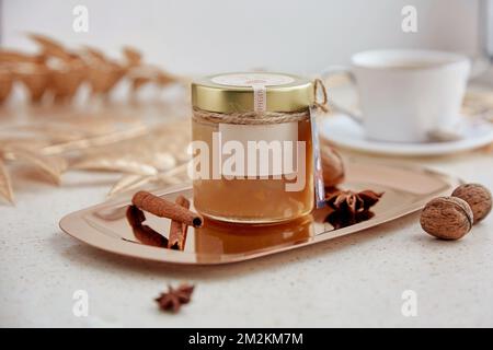 Weihnachtsästhetisches Essen. Hausgemachtes Haselnusskaramell in Glasglas mit nachgeahmtem Etikett in gemütlichen Wohnungen. Stockfoto