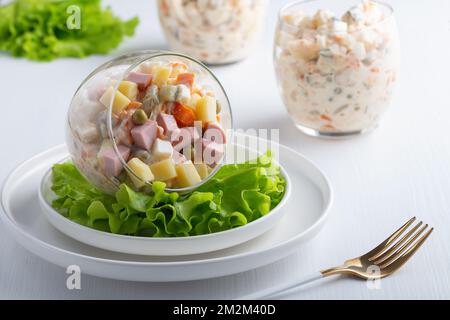 Traditioneller russischer Salat Olivier mit Gemüse, Schinken und Mayonnaise Stockfoto