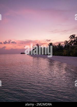 Fantastischer, ruhiger Blick aus nächster Nähe auf ruhige Meereswellen mit orangefarbenem Sonnenaufgang bei Sonnenuntergang. Tropische Insel Strandlandschaft, exotische Küste Stockfoto
