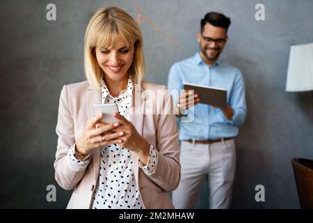Schöne erfolgreiche Geschäftsfrau E-Mails am Telefon in modernen Büro ich zu überprüfen Stockfoto