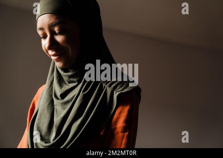 Young beautiful smiling woman in hijab looking downward close-up Stockfoto