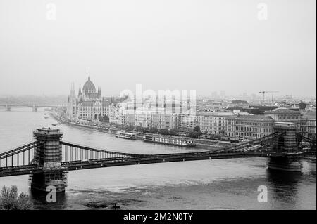 Eine Grauskala der Szechenyi-Kettenbrücke an einem nebligen Tag in Budapest Stockfoto