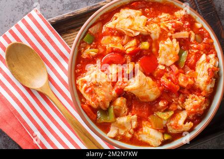 Bacalao al ajoarriero Cod with peppers and tomato sauce closeup on the bowl on the table. Horizontal top view from above Stockfoto