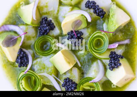 Gourmet-Luxus-Salat mit Blick von oben. Gurke mit Himbeere und Avocado. Blick auf Makroküche auf weißem Teller, köstliche Vorspeise oder vegane Salatvorlage Stockfoto
