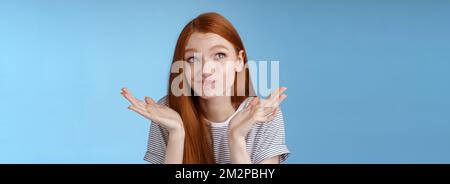 Umständlich unbequem attraktiv Rotschopf beliebtes Mädchen versuchen, denken bis Entschuldigung Gefühl widerwillig stehend zweifelhaft zuckend Hände ausbreiten Stockfoto