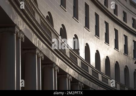 Die untergehende Wintersonne scheint auf die Kurven von kreisförmigem Gebäude, Ruhe, Architektur, Sonnenuntergang, London Stockfoto