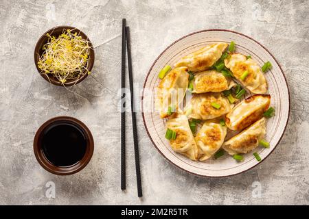 Gyoza, japanische Teigtaschen in der Pfanne, auf hellem Hintergrund. Stockfoto