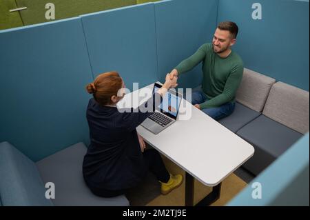 Weiße Frau und bärtiger Mann bei den Vorträgen im Raum. Händedruck für ein Vorstellungsgespräch. Stockfoto