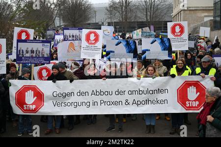 Erfurt, Deutschland. 14.. Dezember 2022. Teilnehmer an einer Versammlung von Ärzten und Apothekern stehen vor dem Thüringer landesparlament. Berufsverbände von Allgemeinärzten, Zahnärzten und Apothekern haben die Kundgebung vor der Sitzung des staatlichen parlaments gefordert. 500 Teilnehmer sind registriert. Die Ärzte fordern einen angemessenen Ausgleich für die Inflation und eine bessere Wertschätzung ihrer Arbeit. Kredit: Martin Schutt/dpa/Alamy Live News Stockfoto