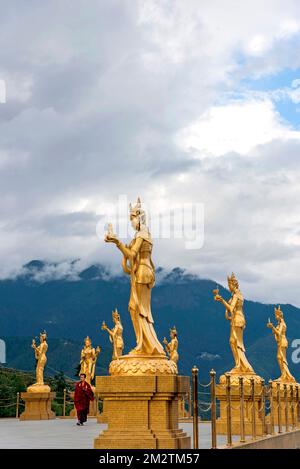 Mönch inmitten goldener Statuen buddhistischer weiblicher Götter im Buddha Dordenma Tempel, Thimphu, Bhutan Stockfoto