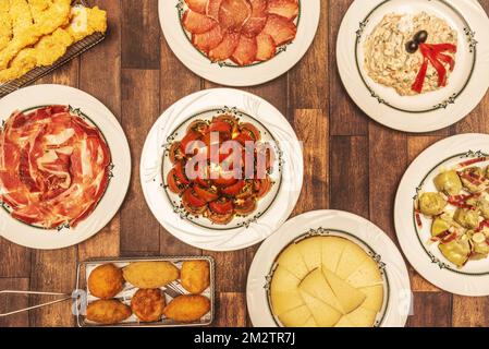 Große Auswahl spanischer Gastronomie und abwechslungsreiche Tapas mit Kroketten, Tomatensalat, Chorizo-Lende, russischem Salat, Sempiterna Tapa aus messergeschnittener AC Stockfoto