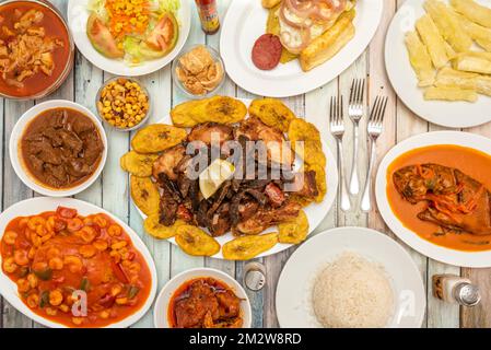 Ein Stilleben typischer karibischer Rezepte mit Roastbeef und Hühnchen mit gebratenen Kochbananen, Mofongo, weißem Reis, Fisch mit Kokosnusssoße, gebratener Yucca, Stockfoto