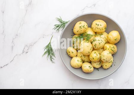 Gekochte Kartoffeln mit Dill auf grauem Hintergrund Stockfoto