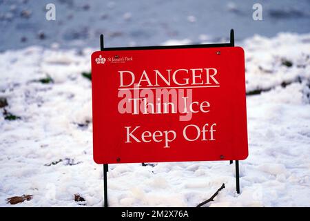 Schild mit Warnung vor dünnem Eis am See in St. James's Park, London. Schnee und Eis haben sich über Teile Großbritanniens ausgebreitet, und die kalten Winterbedingungen werden tagelang anhalten. Bilddatum: Mittwoch, 14. Dezember 2022. Stockfoto