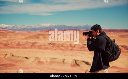 Ouarzazate, Marokko 28. März 2015, Fotograf, der Fotos mit der Wüste und dem Atlasgebirge im Hintergrund macht Stockfoto