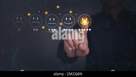 Geschäftsmann drückt Smiley-Gesicht-Emoticon auf virtuellem Touchscreen. Konzept der Bewertung des Kundenservice. Zufriedenheitskonzept. Stockfoto