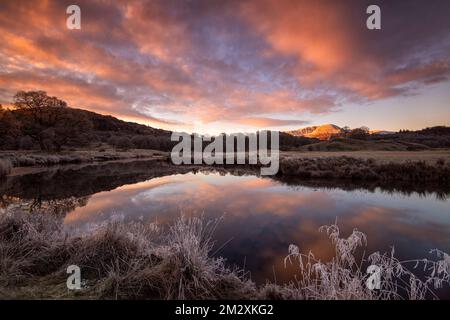 Gefrorener Sonnenaufgang im Winter am Fluss Brathay zwischen Skelwith Bridge und Elterwater im Lake District, Cumbria England, Großbritannien Stockfoto