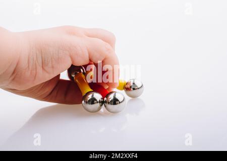 Hand mit magnet Spielzeug bars und magnetische Kugeln auf einem weißen Hintergrund Stockfoto