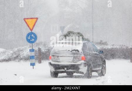 Der Verkehr im Schneesturm am Sonntag. Es schneite in großen Mengen und verursachte große Verkehrsprobleme. Im Bild: Auto mit Weihnachtsbaum auf dem Dach im Winterverkehr. Stockfoto