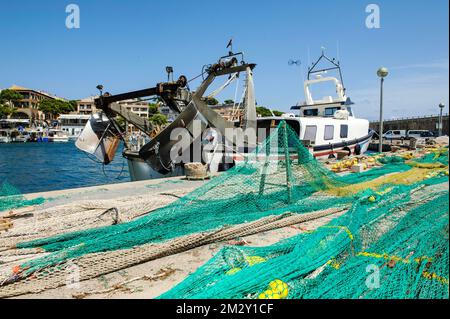 Fischernetze, die zur Reparatur am Kai am Hafen, Cala Ratjada, Mallorca, Balearen, Spanien ausgestreckt und getrocknet sind Stockfoto