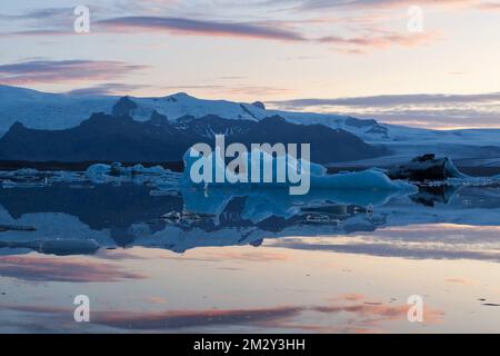Wunderschöner Sonnenuntergang mit schmelzenden Eisbergen in smaragdtürkisblauem Blau in der Jokulsarlon Gletscherlagune. Island.