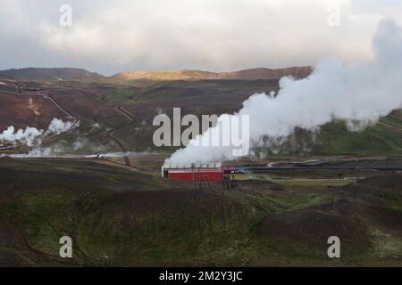 Das geothermische Kraftwerk Krafla wird dampfend betrieben. Vulkangebiet Myvatn, Island, Europa. Dampf kommt aus Rohren. Farbenfrohe, grüne und braune Hügel und Berge Stockfoto