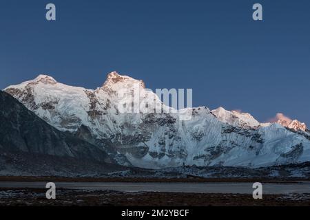 Abendlichter über dem Berggipfel Cholatse in Himalaya, Nepal. Highlands-Landschaft der Bergkette in rosa Dämmerung. Wunderschöner Hintergrund Stockfoto