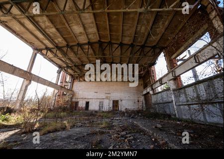 Ein verlassenes Lagerhaus, das von Menschen und Zeit zerstört wurde, ein zerstörtes Industriegebäude. Stockfoto