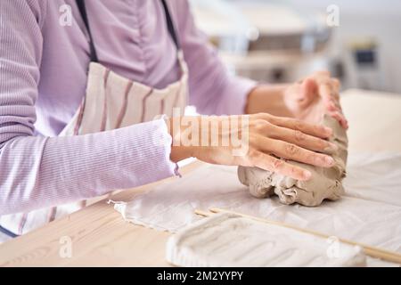 Frau Töpfer arbeitet mit Ton, Nahaufnahme von oben weibliche Hände halten ein Stück nassen Ton in ihren Händen. Der Töpfer erzeugt ein Produkt. Hochwertiges Foto Stockfoto