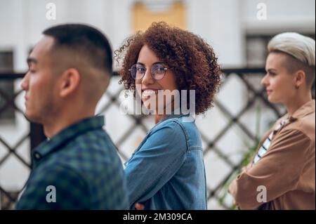 Joyful young female posing for the camera with her companions Stockfoto