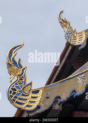 Wunderschöne blaue und goldene Naga-Dekoration aus Holz auf dem abgestuften Dach des buddhistischen Tempels Wat Prasat, antikes Viharn, Chiang Mai, Thailand Stockfoto