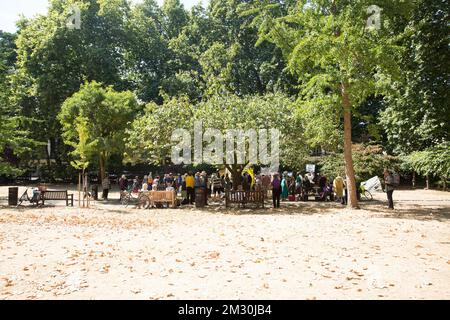 Die Menschen versammeln sich in der Nähe des Kirschbaums, der zum Gedenken an die Opfer von Hiroshima während einer Gedenkveranstaltung am Tavistock Square im Zentrum von London gepflanzt wurde. Stockfoto