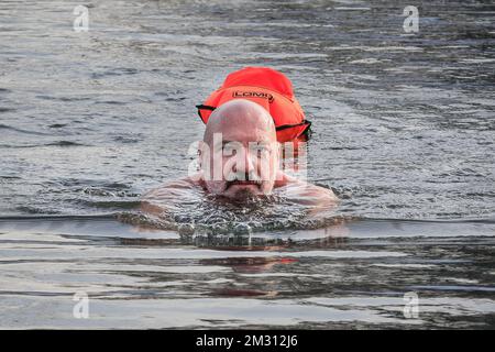 London, Großbritannien. 14.. Dezember 2022. Schwimmer Bernd ist gekommen, um zu schwimmen und erstickt das Wasser mit einem Lächeln. Schwimmer trotzen dem kalten, aber sonnigen Wetter und schwimmen im offenen Wasser im Beckenham Place Park Swimming Lake, einem See in natürlicher Umgebung im Beckenham Place Park im Südosten Londons. Zwei voll ausgebildete Rettungsschwimmer sind anwesend mit Rettungsausrüstung für die gebuchten Schwimmgänge im offenen Wasser und alle Schwimmer hatten Einführungssitzungen zum Schwimmen im Winter und Sicherheitsmaßnahmen und schwimmen mit einer Rettungsboje. Kredit: Imageplotter/Alamy Live News Stockfoto