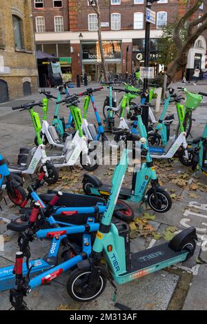 Eine große Anzahl von E-Scootern, die Teil des Mietprogramms für E-Scooter von Transport for London sind, versperrte den Bürgersteig. Clerkenwell Road, London, Großbritannien Stockfoto