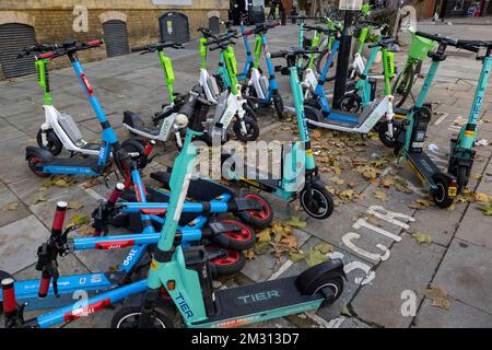 Eine große Anzahl von E-Scootern, die Teil des Mietprogramms für E-Scooter von Transport for London sind, versperrte den Bürgersteig. Clerkenwell Road, London, Großbritannien Stockfoto