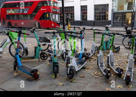 Eine große Anzahl von E-Scootern, die Teil des Mietprogramms für E-Scooter von Transport for London sind, versperrte den Bürgersteig. Clerkenwell Road, London, Großbritannien Stockfoto