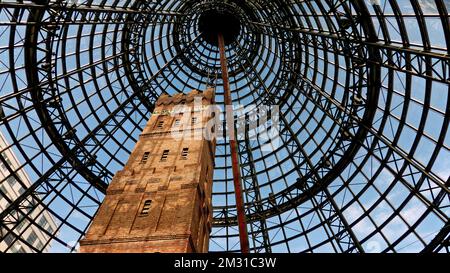 Coop's Shot Tower ist ein Turm im Herzen von Melbourne CBD, Australien. Es wurde 1889 fertiggestellt und ist 50m m hoch. Das historische Gebäude wurde 1973 vor dem Abriss bewahrt und 1991 unter einem 84 m hohen konischen Glasdach in den Melbourne Central Komplex integriert. Ein Turm ist ein Turm, der für die Herstellung von Kugeln mit kleinem Durchmesser durch freien Fall von geschmolzenem Blei ausgelegt ist, das dann in einem Wasserbecken gefangen wird. Die Aufnahme wird hauptsächlich für Projektile in Schrotflinten sowie für Vorschaltgeräte, Strahlenschutzschirme und andere Anwendungen verwendet, bei denen kleine Bleikugeln nützlich sind. Stockfoto