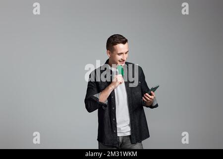 Attraktiver Mann mit Smartphone und Kreditkarte Stockfoto
