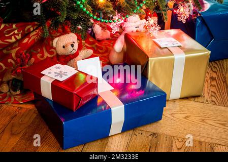 Festliche Momente - eingewickelte Weihnachtsgeschenke unter dem Baum Stockfoto