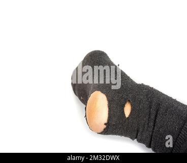 Füße eines armen Rentners. Löcher in der Socke Stockfoto