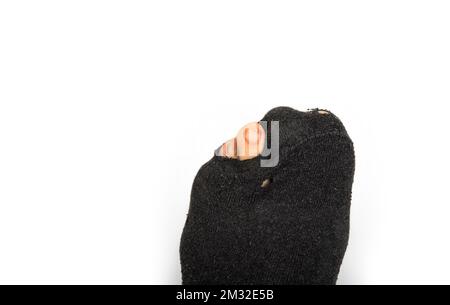 Füße eines armen Rentners. Löcher in der Socke Stockfoto