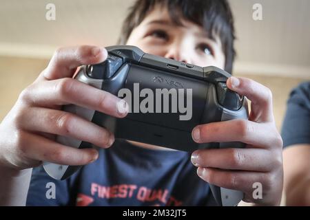 Die Abbildung zeigt einen Jungen, der am Donnerstag, den 26. März 2020, mit einer Xbox-Spielkonsole in Vezin spielt. Ab März 18. werden neue Maßnahmen ergriffen, um die Ausbreitung der COVID-19-Pandemie zu verhindern. BELGA FOTO BRUNO FAHY Stockfoto