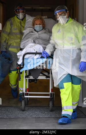 Krankenwagenfahrer Hugo und Chris transportieren Jeanne, eine 88-jährige, die von einem Covid-19-Patienten geheilt wurde. Sie arbeiten für das Ambulance Centrum Antwerpen, das für den Transport von Covid-19-Patienten zuständig ist, in Antwerpen, Freitag, den 27. März 2020. Ab März 18. werden neue Maßnahmen ergriffen, um die Ausbreitung der COVID-19-Pandemie zu verhindern. In Belgien sind bisher 7284 Menschen infiziert. BELGA FOTO DIRK WAEM Stockfoto