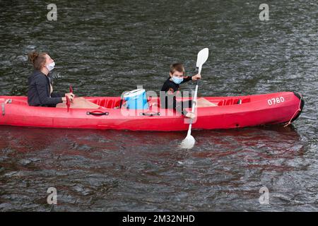 Abbildung zeigt zwei Jungen mit einer Mundmaske, die eine Fahrt in einem Kanu auf dem Fluss Lesse in Gendron beginnen, Samstag, 23. Mai 2020. Belgien befindet sich in der zehnten Woche seiner Eindämmung in der anhaltenden Coronavirus-Krise, aber es ist auch die erste Woche der Phase 2 der Dekonfination. Der Nationale Sicherheitsrat hat die von der Sachverständigengruppe für die Ausstiegsstrategie ausgearbeitete "Go to the Deconfinement" in Etappen erteilt. BELGA FOTO NICOLAS MAETERLINCK Stockfoto