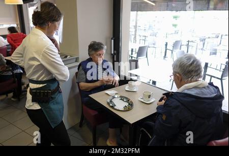 Abbildung zeigt einen Kellner und Kunden in einem Café in Hannut, Montag, den 08. Juni 2020. Heute ist der erste Tag der Phase 3 der Dekonfination. Der Horeca-Sektor kann sich wieder öffnen, muss aber in seinen Unternehmen Regeln der sozialen Distanzierung anwenden. BELGA FOTO ERIC LALMAND Stockfoto