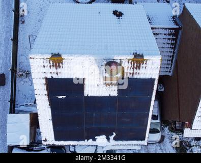 Sonnenkollektoren auf einem schneebedeckten Dach in Großbritannien Stockfoto